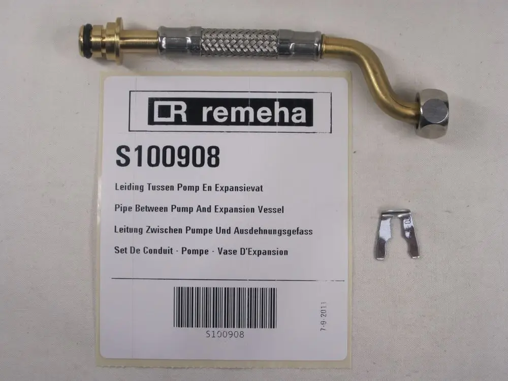 Remeha Rohrverbindung zwischen Pumpe und Ausdehnungsgefäß mit Metallummantelung und Anschlussstücken, neben einer Produktbeschreibung auf einem Etikett.